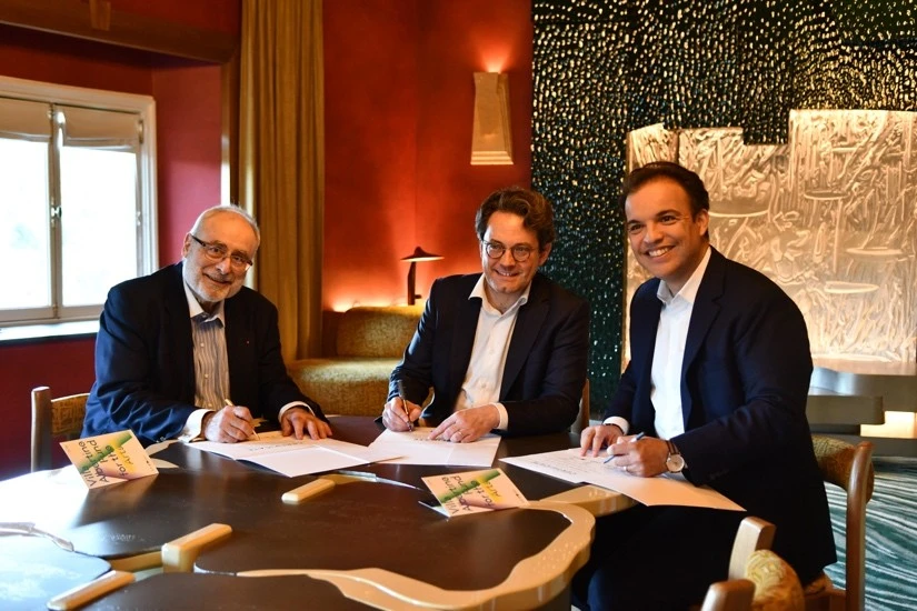 Three representatives sign the partnership agreement at Villa Albertine in New York.